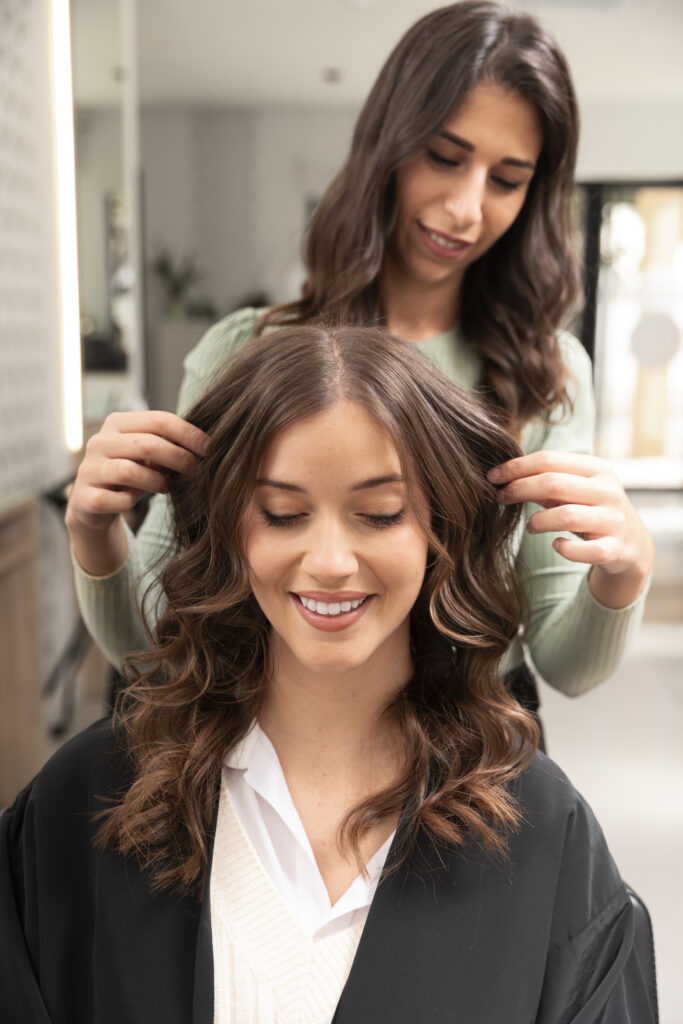a happy girl showing her hair in women salon salon Oakville
